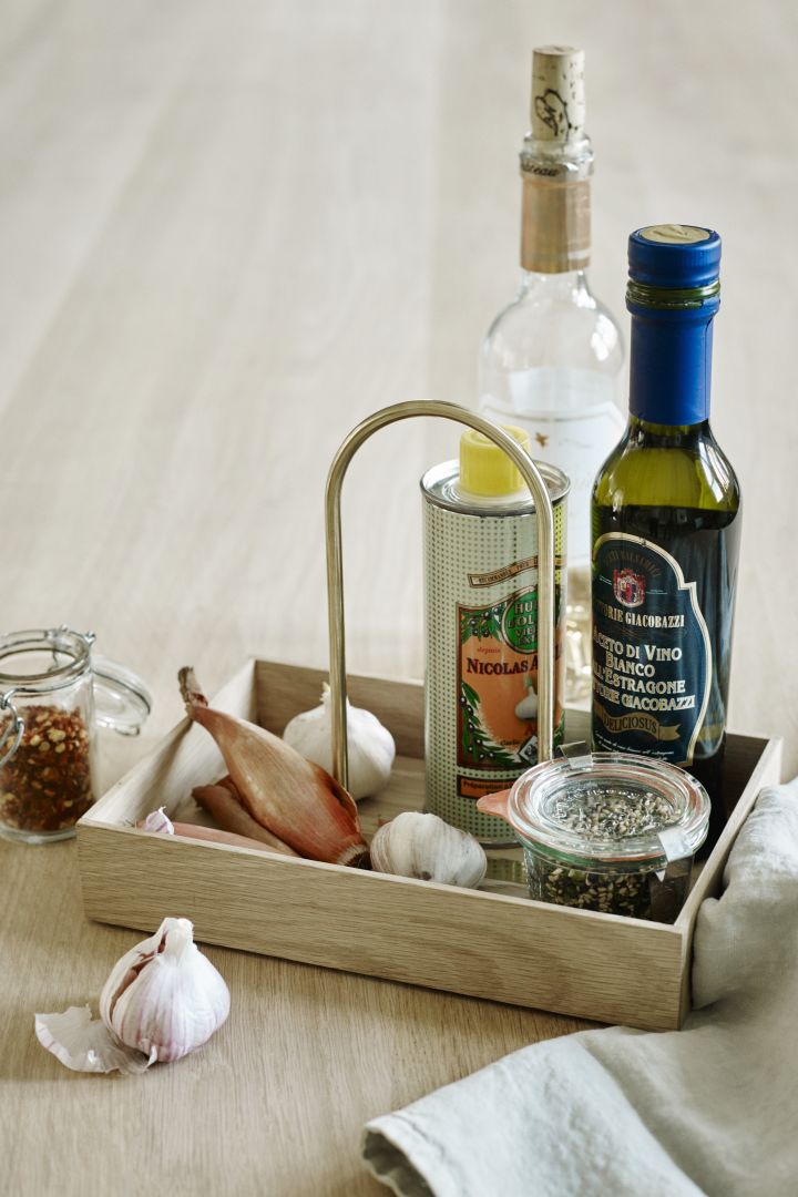 En box i trä från Skagerak är perfekt att använda till att gruppera olije- och vinägerflaskor på i köket. 